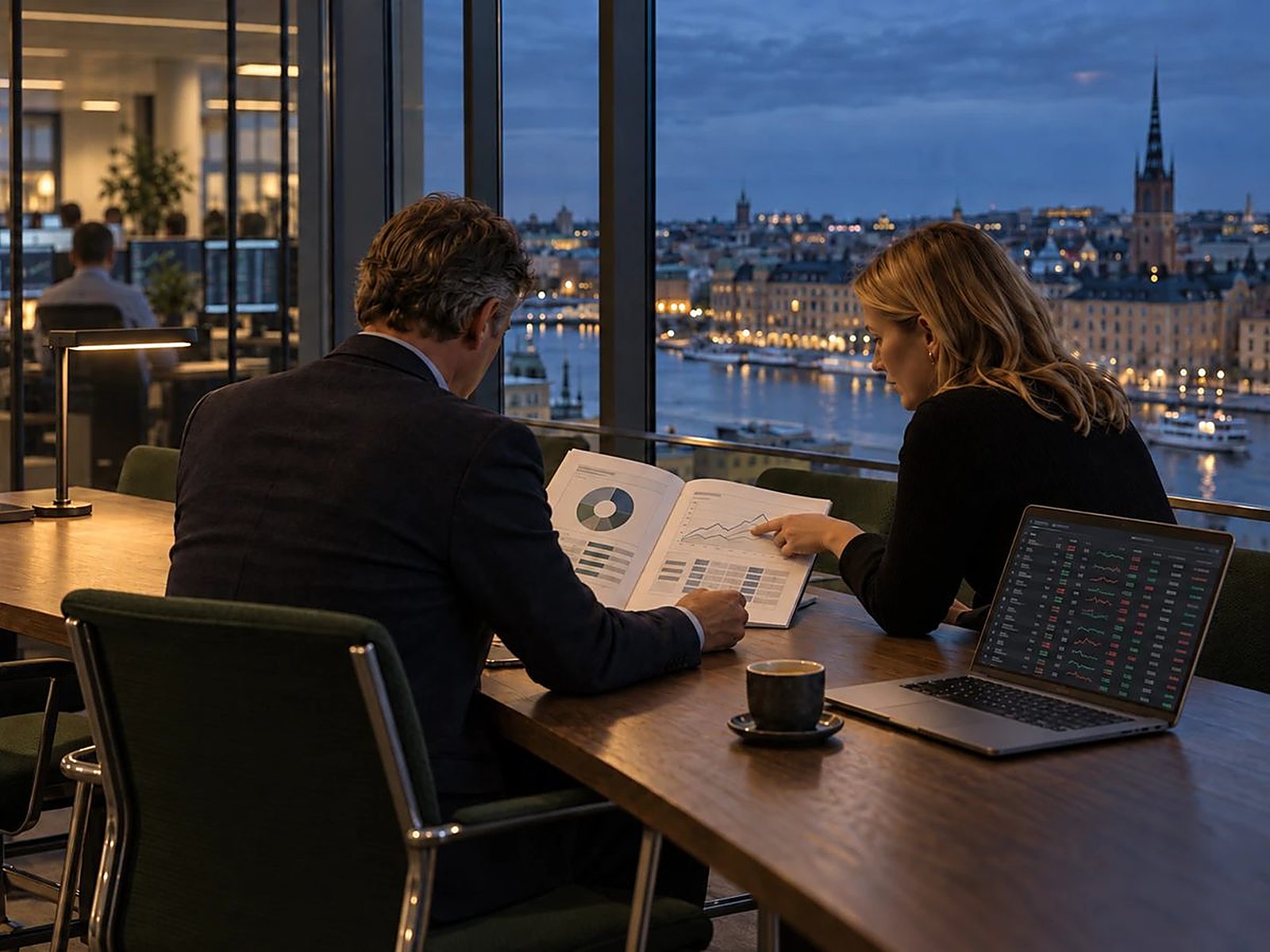Two people reviewing a report in an office overlooking Stockholm at dusk